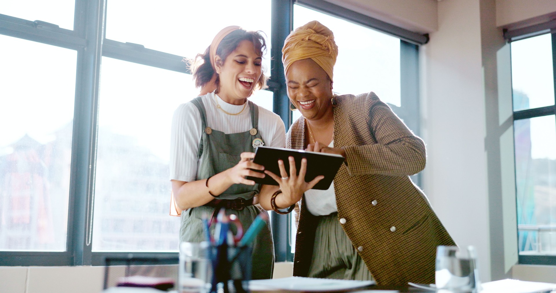 Tablet, Teamwork und lustige Geschäftsfrauen im Büro eines Startup-Unternehmens. Technologie, Lachen und Zusammenarbeit von glücklichen kreativen Menschen, die gemeinsam Meme, Comedy und Internetwitze in den sozialen Medien lesen